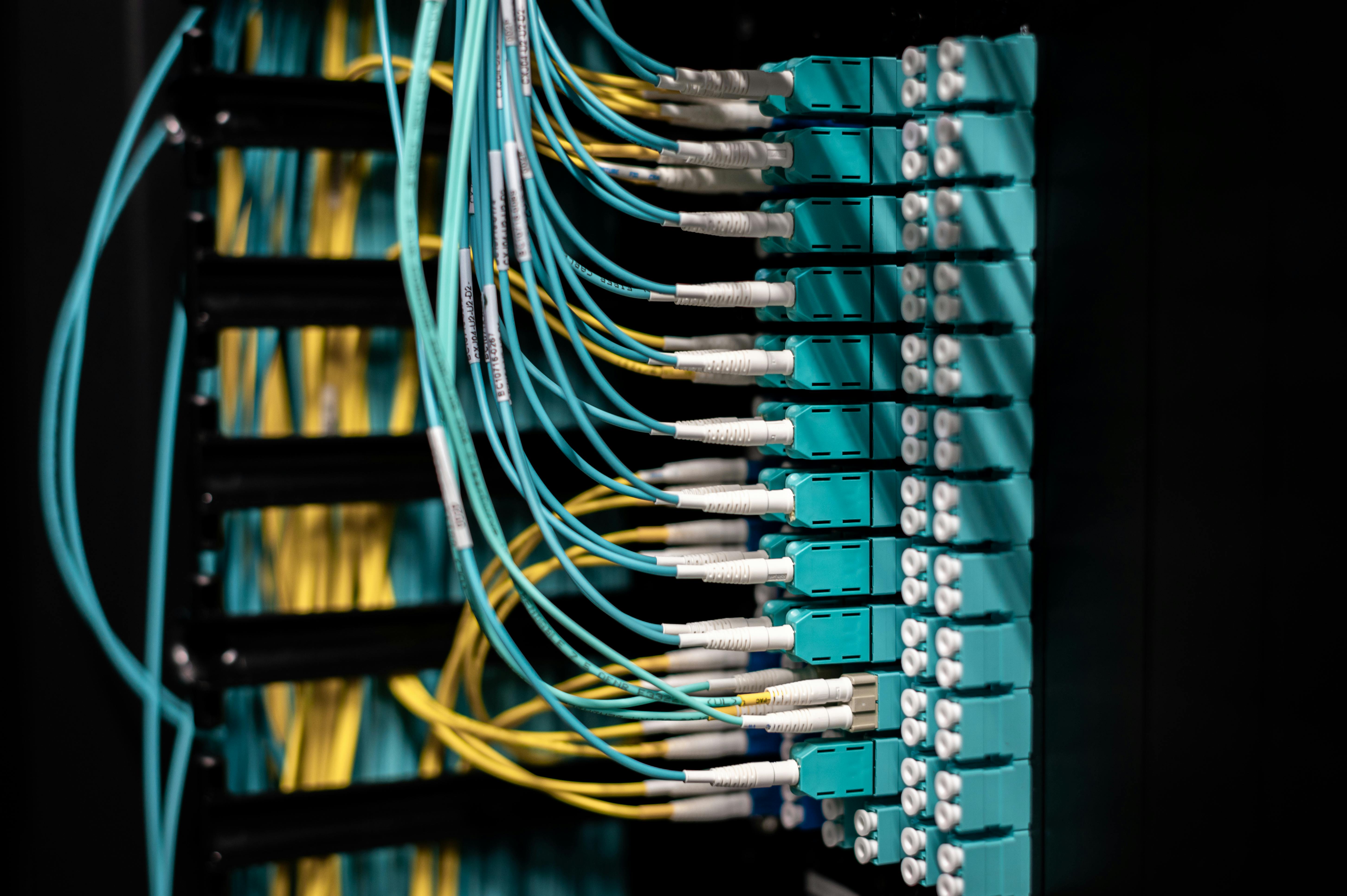 Fiber optic cables with glowing light strands emerging from a dark casing